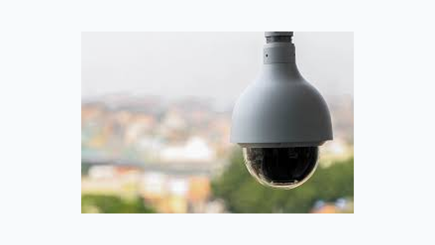 Câmara de vigilância dome com fundo urbano desfocado.